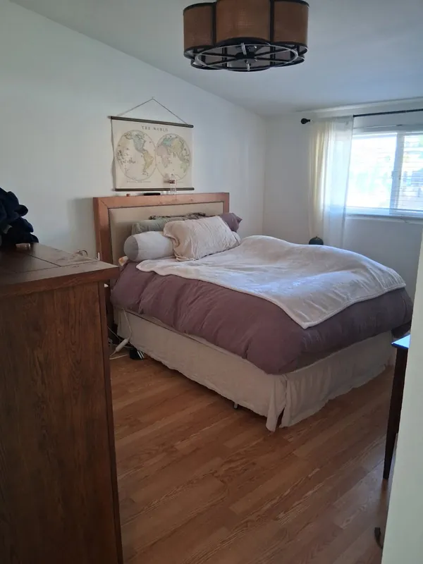 The same bedroom with the bed made and the floor clear, after the deep cleaning