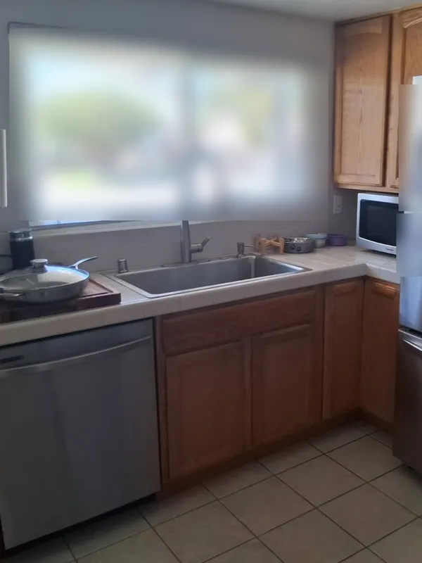 The same kitchen with the sink empty and the counter clear, after the deep cleaning