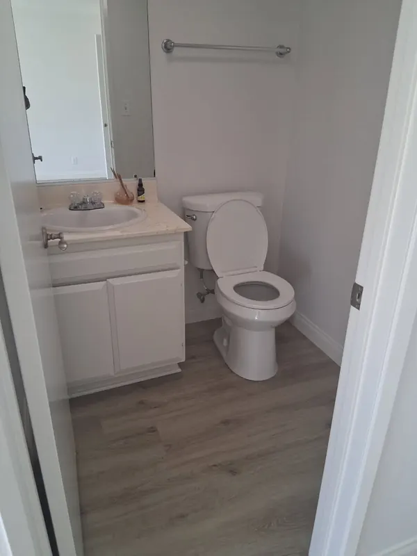 Half bathroom with a white vanity and wood-look floor after a move-in cleaning in Thousand Oaks