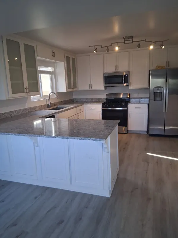 Kitchen with white shaker cabinets, granite counters and a stainless range after a move-in cleaning in Thousand Oaks