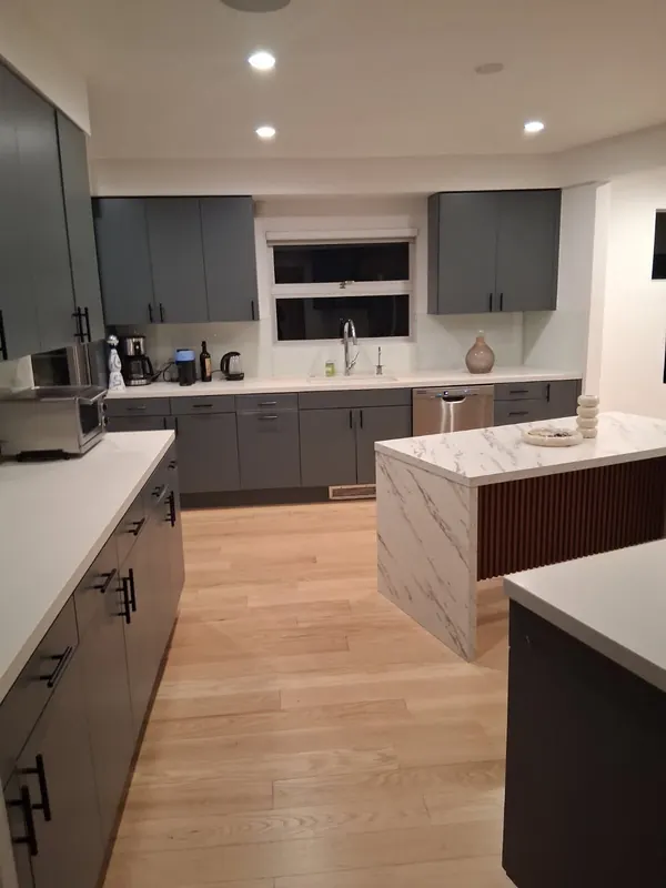 Kitchen sink wall with grey cabinets and clear white counters after a regular cleaning in Beverly Hills